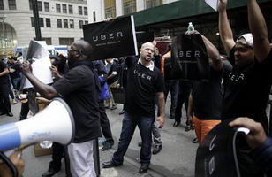 Uber drivers and their supporters protest in front of the offices of the Taxi and Limousine Commission in New York, Thursday, May 28, 2015. Uber and Lyft are pushing back against a New York City effort to regulate app-based car services. The proposal before the Taxi and Limousine Commission would require car services that riders can summon with their phones to comply with many of the rules that govern the yellow cabs they compete with. (ANSA/AP Photo/Seth Wenig)